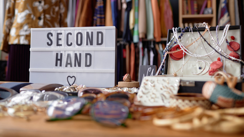A thrift store with a table holding a sign that says 