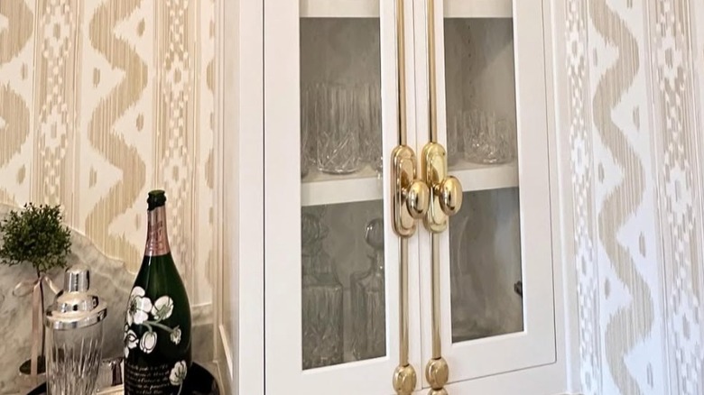 gold cremone bolts on kitchen cabinetry with glassware inside the cabinets