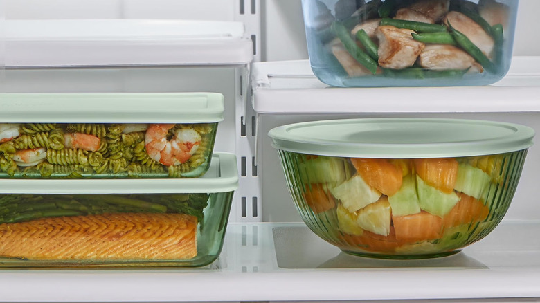 One of the tinted glass Pyrex mixing bowls being used as storage in the refrigerator alongside other Pyrex glassware