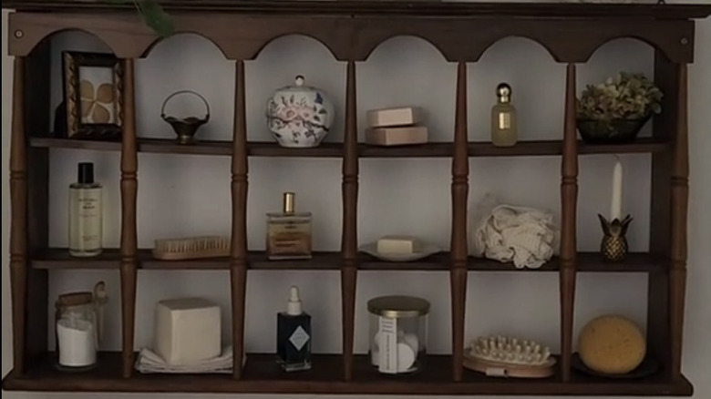 A wooden spindle shelf with bathroom products.
