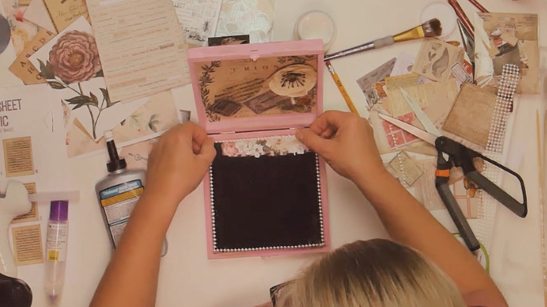 A cigar box being decorated into a jewelry box