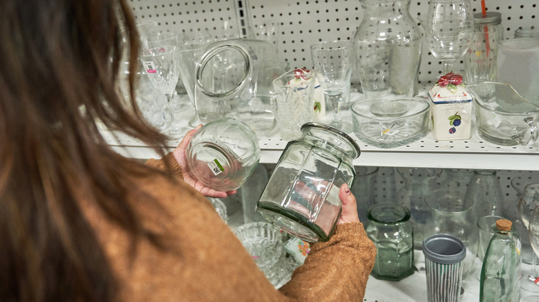 Woman browsing jars at a thrift store