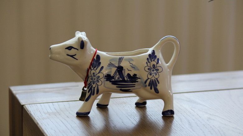 A blue and white cow creamer on table
