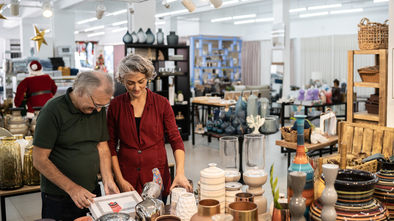 Couple browsing various decor pieces in thrift store