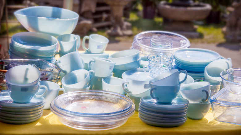 blue Fire King cups, bowls, and plates stacked on a table