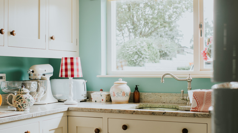 Cottagecore kitchen with white cabinetry and mint blue walls