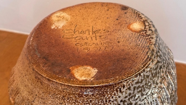 Bottom of a pottery piece made by Charles Counts, showing his maker's mark and the year.