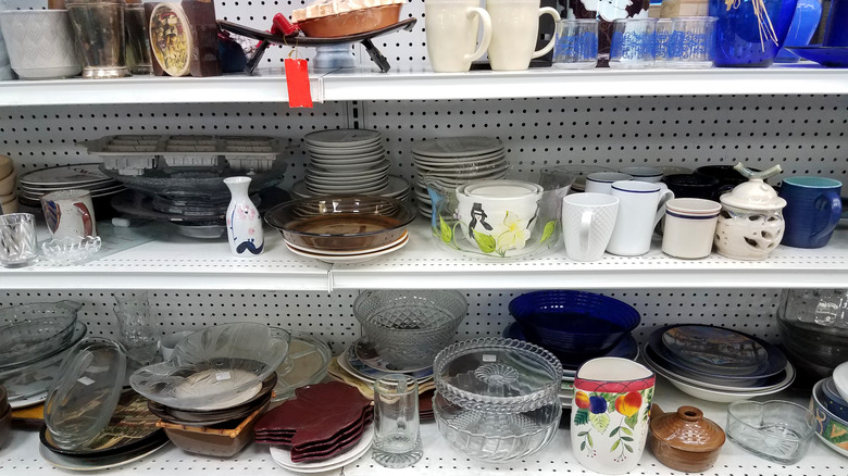 Assorted dishware on the shelves of a thrift store