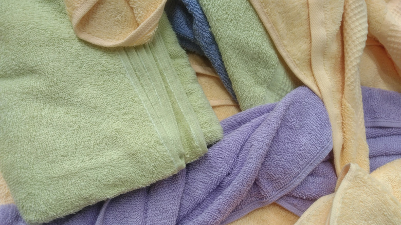A pile of messy towels, waiting to be organized with a thrift store find.