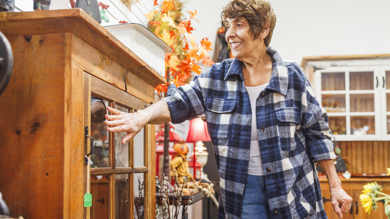 Woman in plaid shopping for thrift store furniture