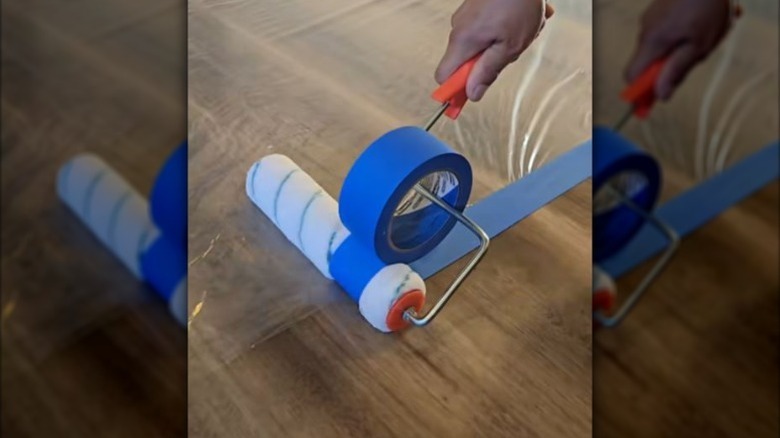 person using paint roller to apply tape