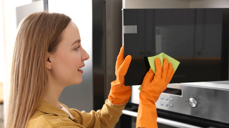 Woman cleaning a microwave