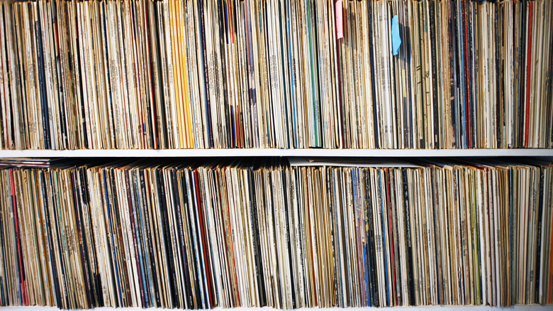 Crowded vinyl records on a shelf.