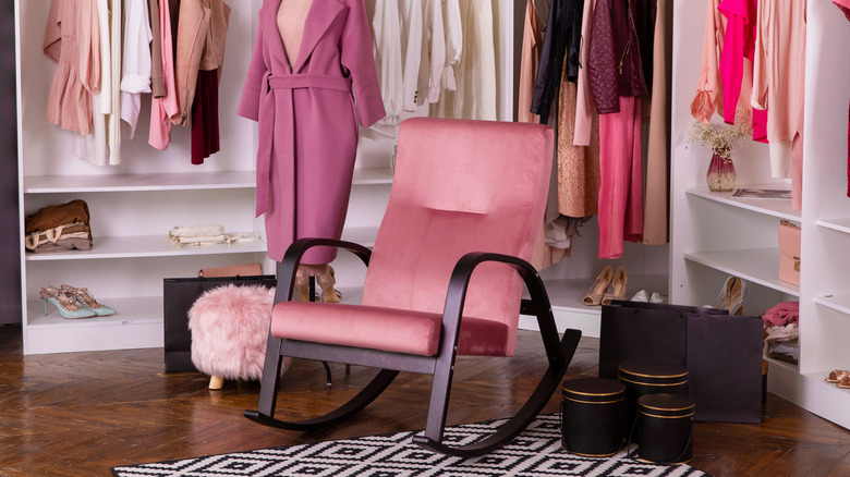 A pink chair in a walk-in closet