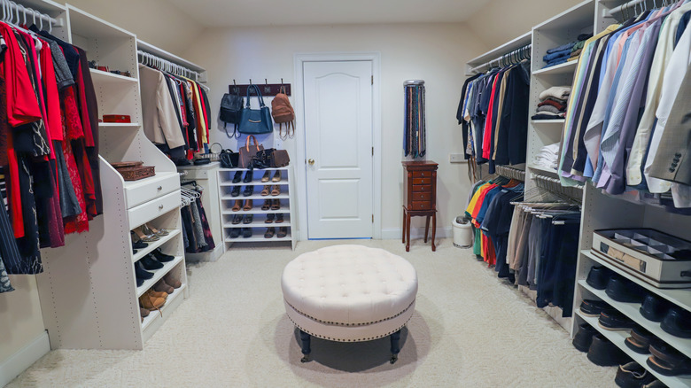 A large closet with an ottoman in the center