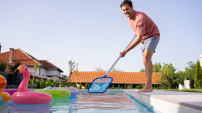 man cleaning swimming pool