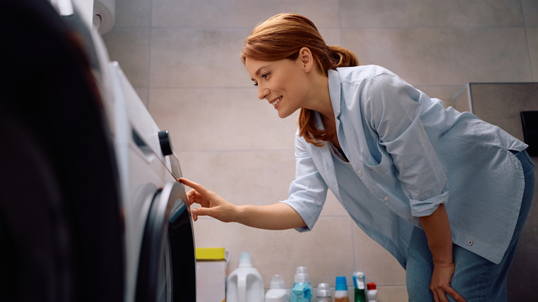 woman selecting timer on washing machine