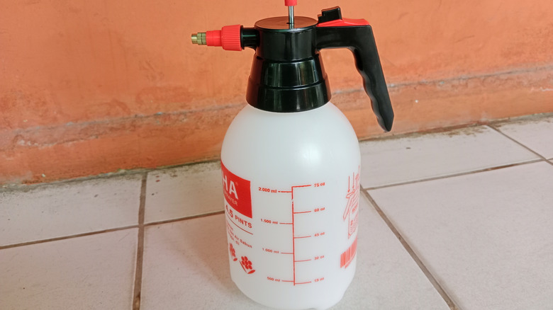Water sprayer canister on a tiled floor