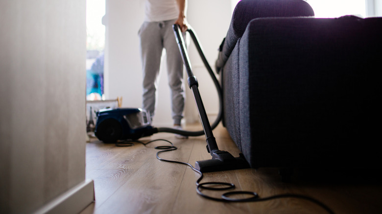 Person using upright, corded vacuum