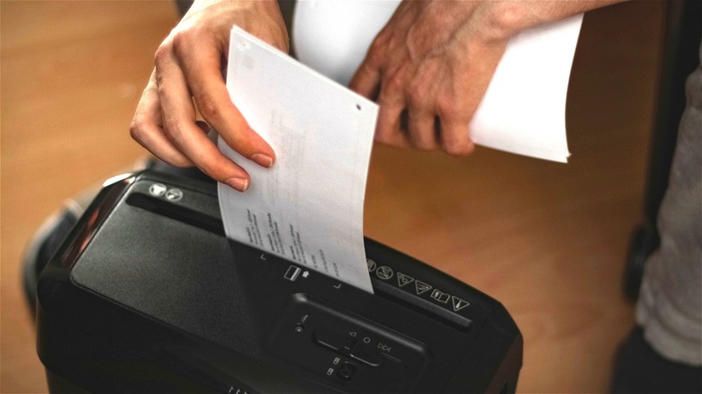 Hand putting paper into shredder