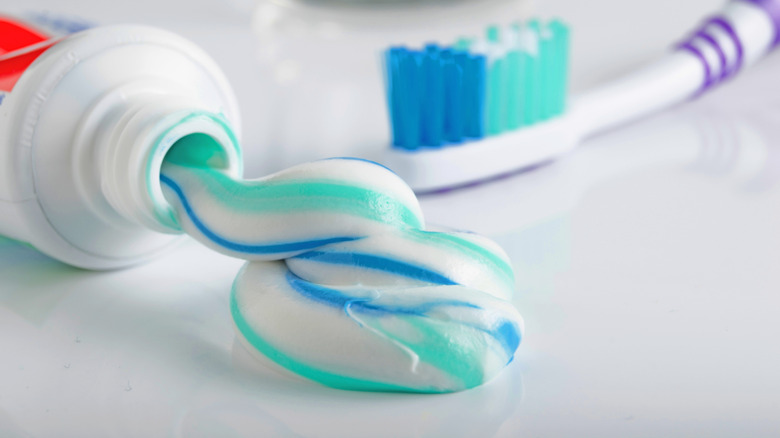 Open toothpaste tube and brush on countertop