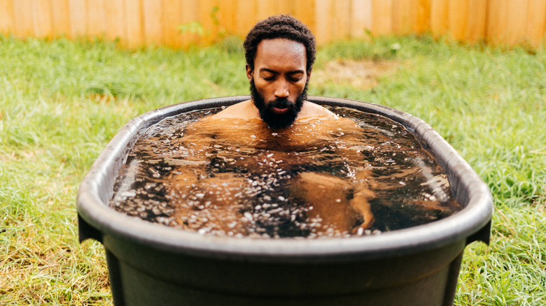 Man doing a cold plunge in his backyard