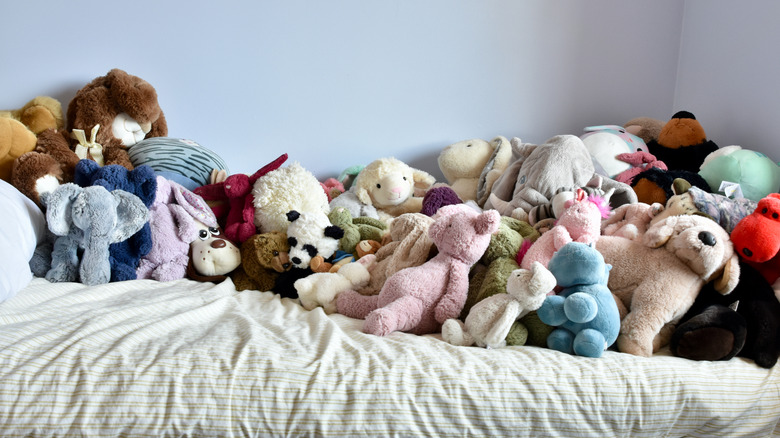 Piles of plushies on a bed.