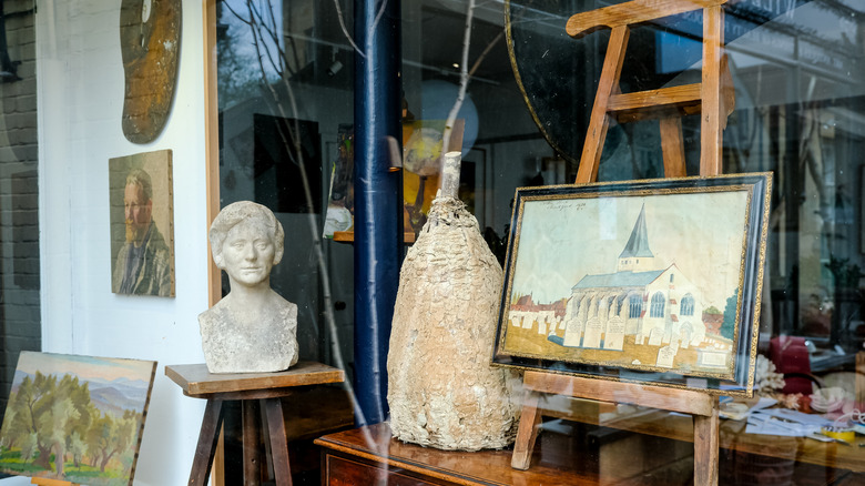 Window of an antique shop with art and sculptures