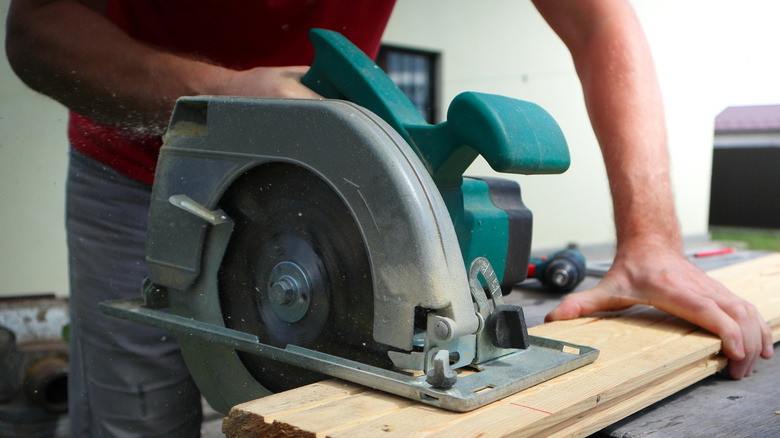 A man using an electric circular saw