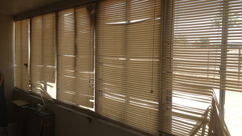 Broken horizontal blinds making a room look dingy