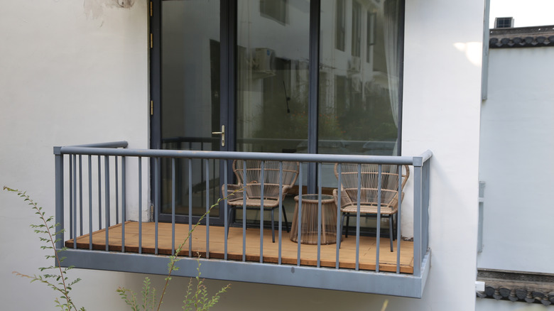 Balcony with gray railing and set of chairs