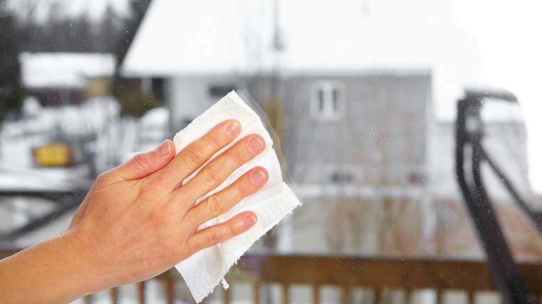 Hand wiping window in the winter