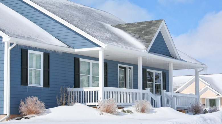 Blue and white house covered in snow and ice