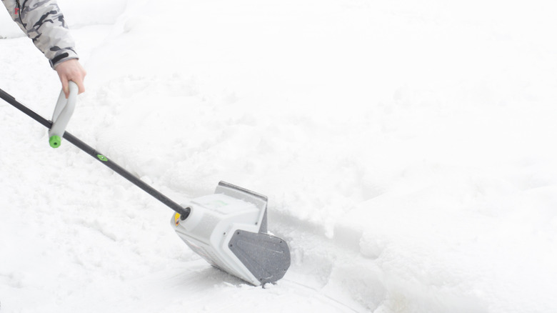 Person using an electric snow shovel