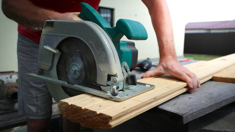 A person cutting wood with a saw