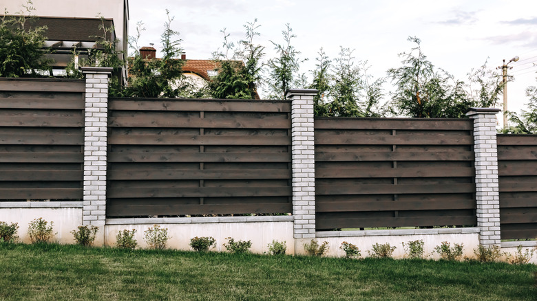 House with horizontal board-on-board wood fencing