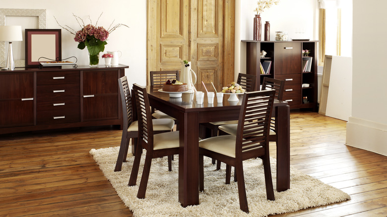 Clean dining room with dark wood furniture and white walls