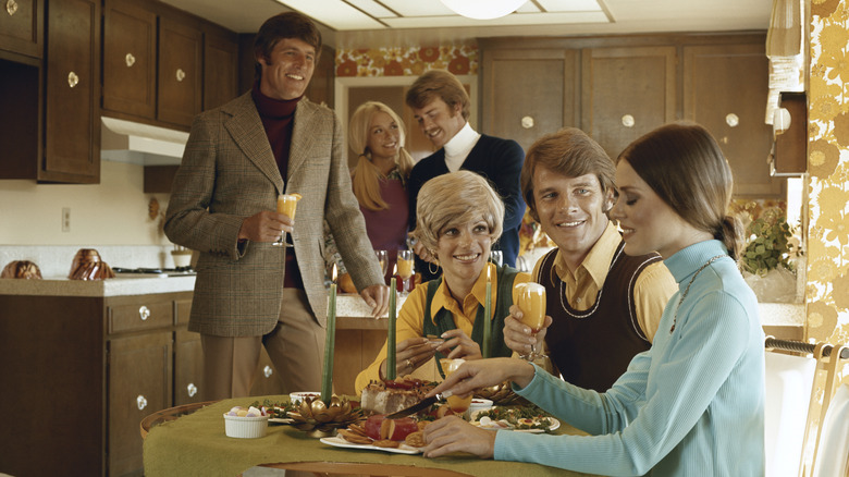 People in the 1970s gathered in a retro kitchen