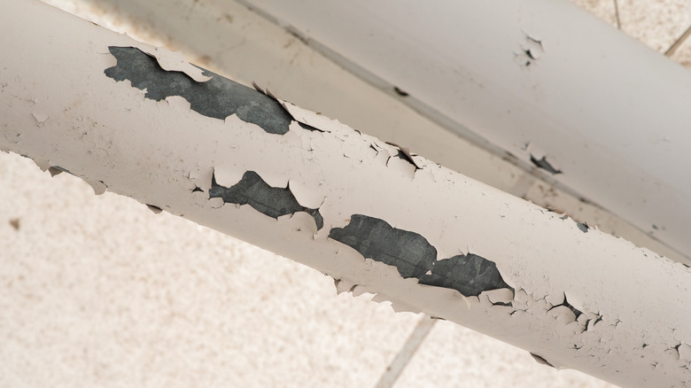 Paint chipping off an old pipe that may contain lead