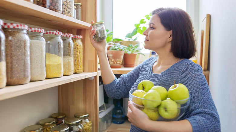 woman with apples in pantry