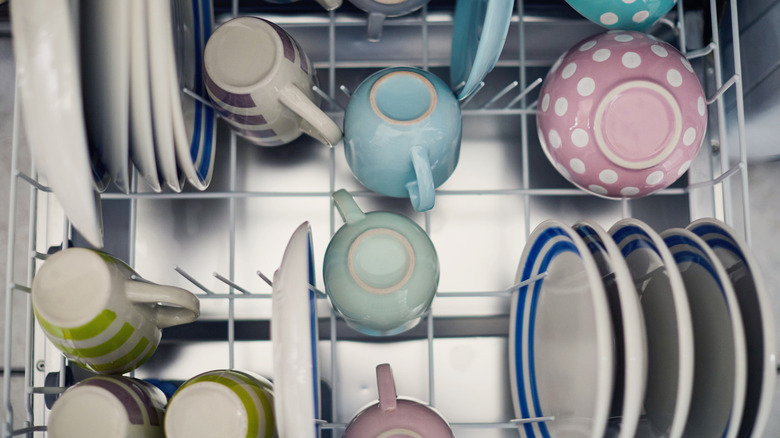 A correctly loaded dishwasher with plates and mugs