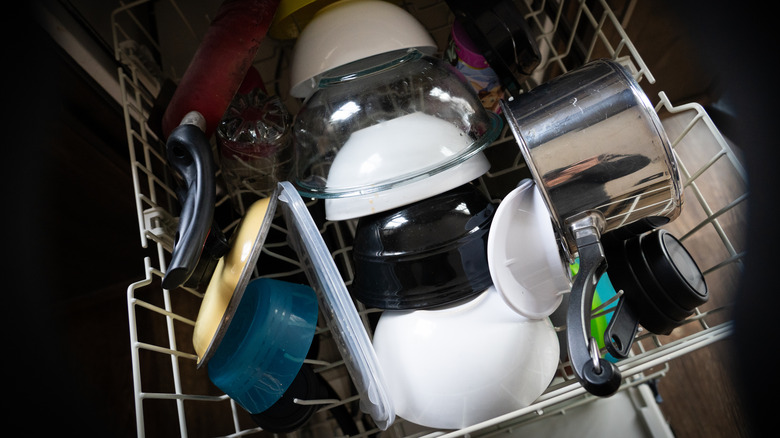 An overcrowded and incorrectly loaded dishwasher rack