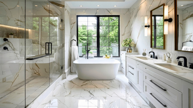 white marble bathroom with glass shower and white standalone tub