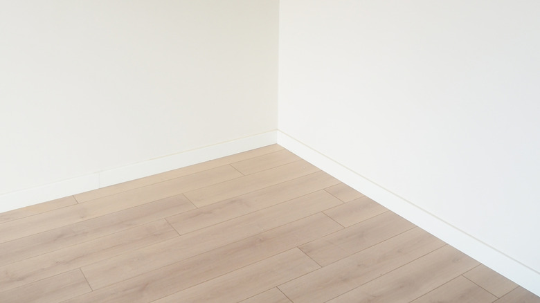 empty room corner wiith whilte walls and light wood floors