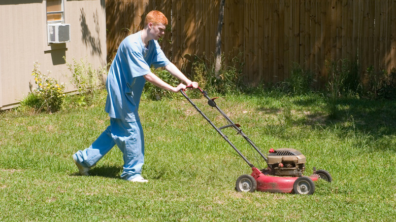 young man mowing on a hot day