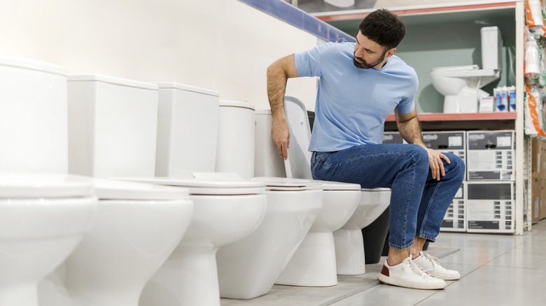 Person sitting on toilets in a shop