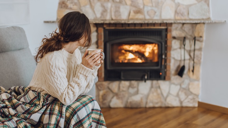 person sitting by fireplace