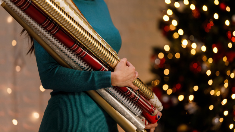 woman holding wrapping paper rolls
