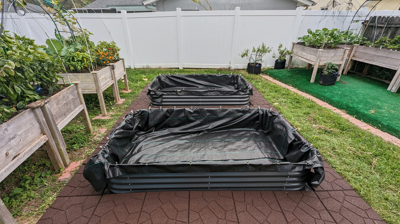 Metal raised garden beds covered with landscape fabric