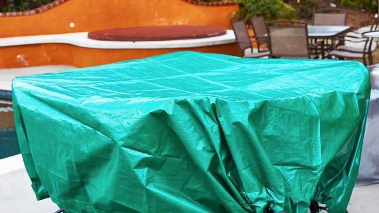 Green Harbor Freight drawstring tarp draped over patio set outdoors